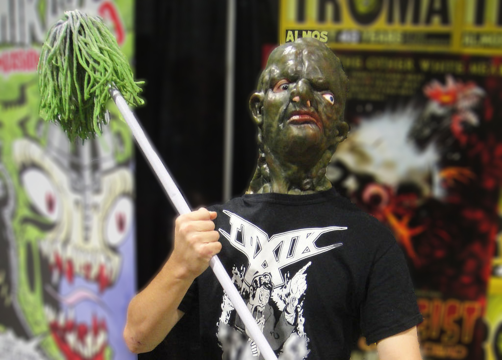 [PHOTO] Someone dressed as the Toxic Avenger at Comic Con, wearing a black t shirt and holding a green mop