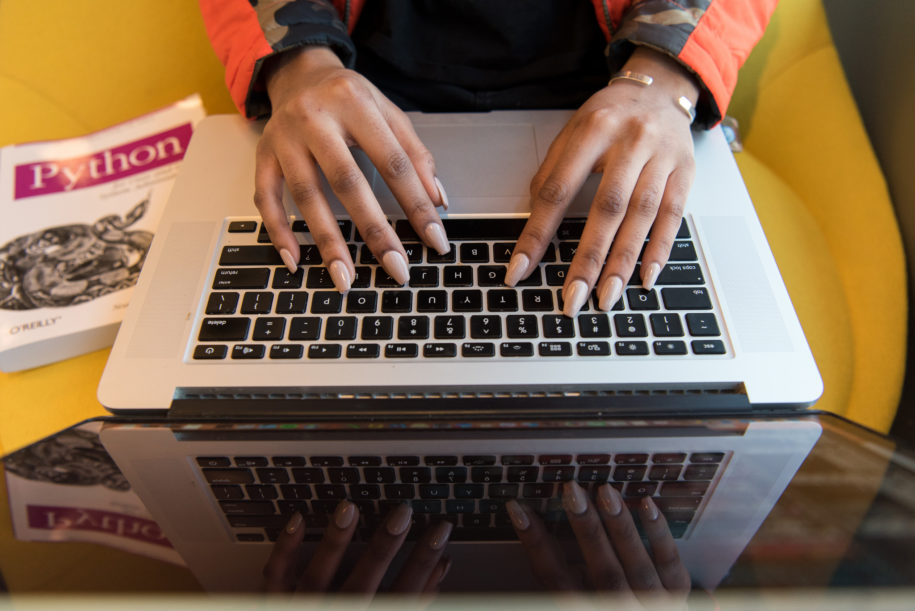 A pair of hands type on a laptop keyboard (Image: WOCInTechChat, CC-BY)
